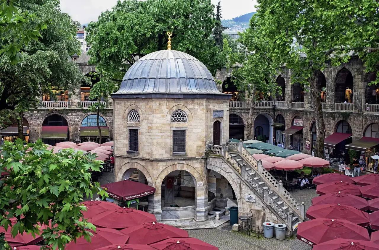 Bursa Koza Han avlusundaki kubbeli mescit, taş merdivenler ve iki katlı kemerli revaklar