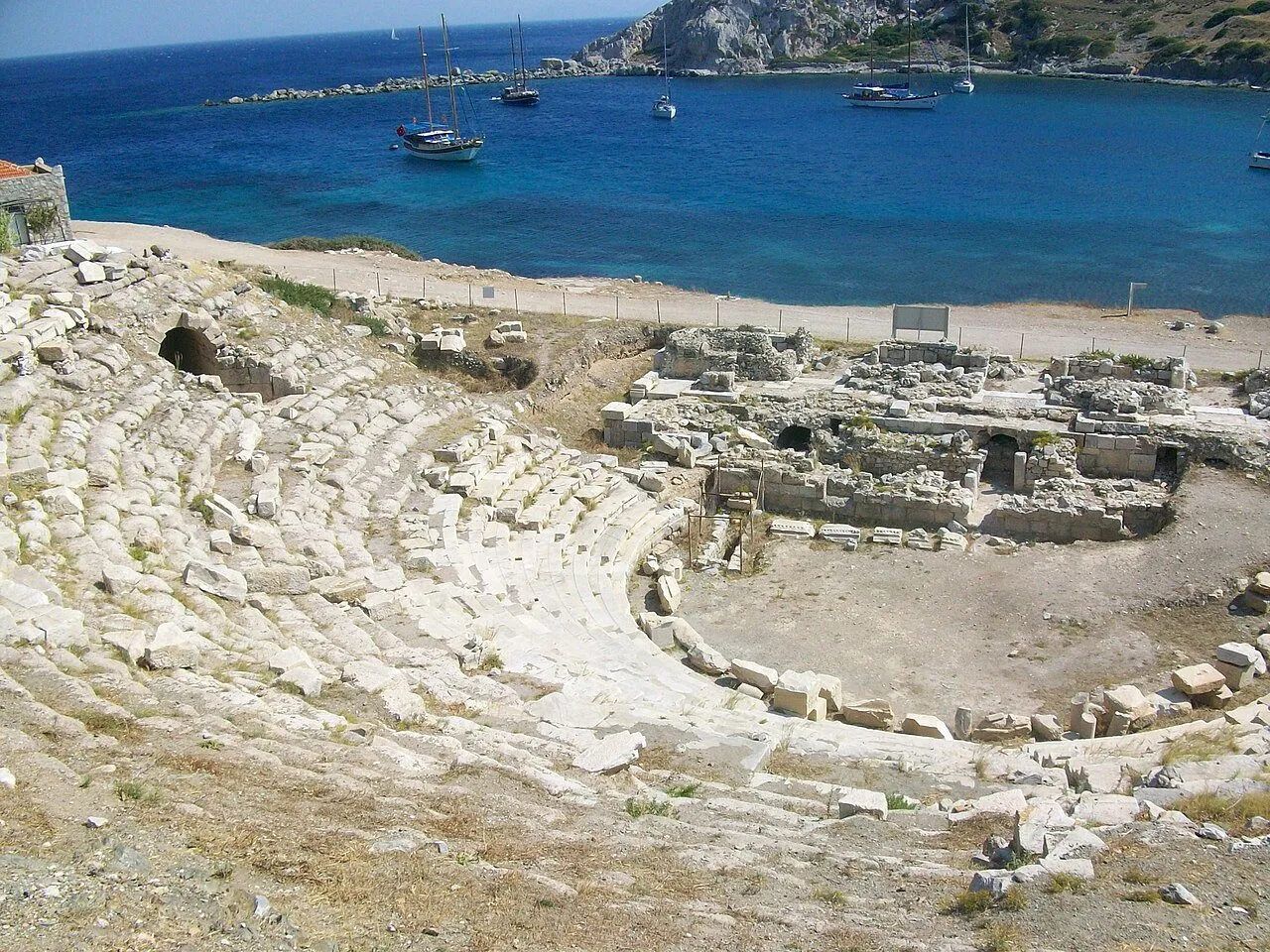 Knidos tiyatrosunun taş oturma sıraları ve arkasındaki liman koyu