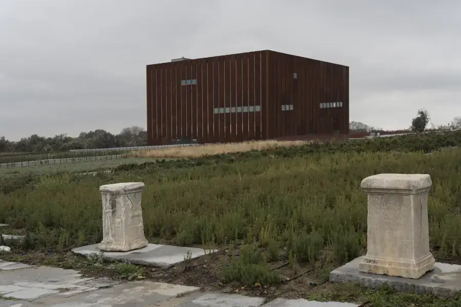Tevfikiye’deki Troya Müzesi’nin kahverengi metal kaplı küp biçimli binası ve bahçedeki taş eserler